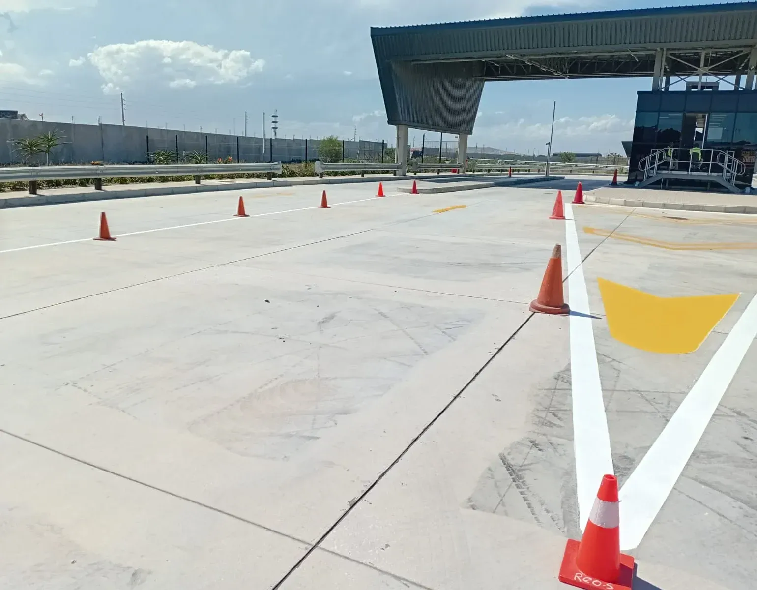 Freshly applied white lines and yellow chevron markings on a newly built toll plaza approach in Cape Town